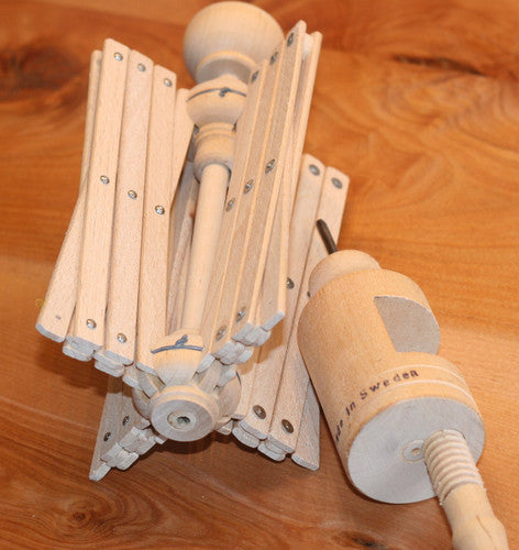 yarn winder laying on a wooden table, unassembled