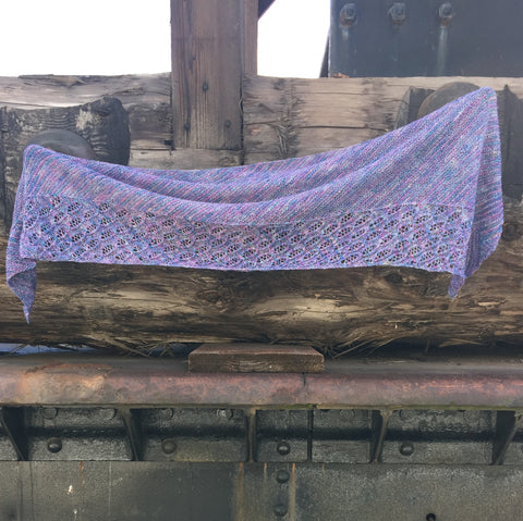 Joyous Mermaid Shawl in purple hung from a wooden wall