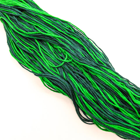 An up-close image of light and dark green mulberry silk lace weight yarn.