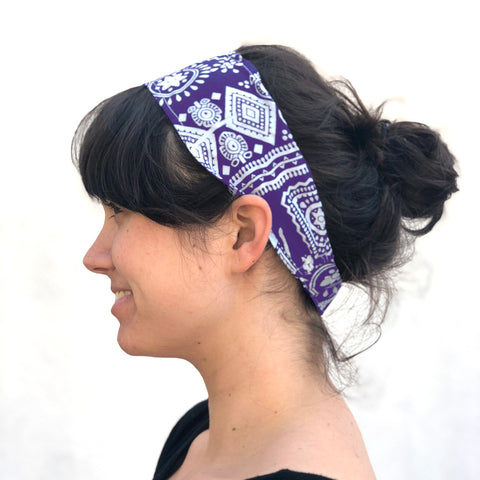 Close up of woman wearing an Indian Cotton Headband in purple in front of a white wall