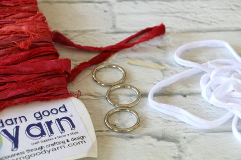 3 metal rings and a yarn sample card on a white surface