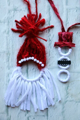 santa and snowman crafts made of ribbons sitting on a white surface