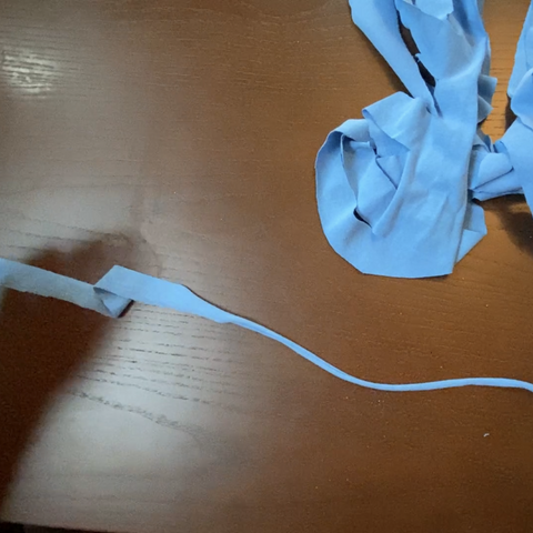 The blue strands of t-shirt fabric are thin like ribbon when they're cut. If you stretch the ribbon, the strands will become round. 