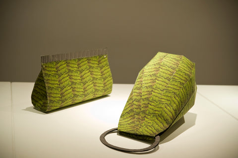 A green clutch next to a green purse.