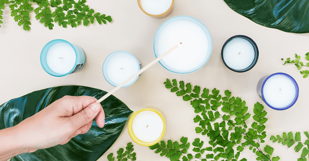 6 small coloured candles plus one big candle being lit with leaves in background