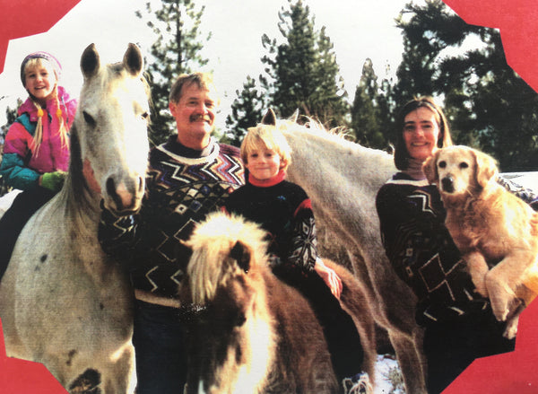 mom, dad, and two kids with three horses and a dog