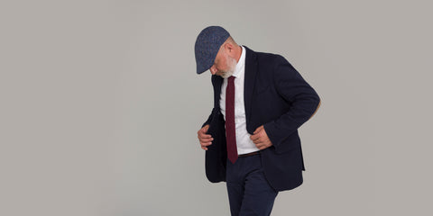 Man wearing a suit, tweed tie and tweed flat cap