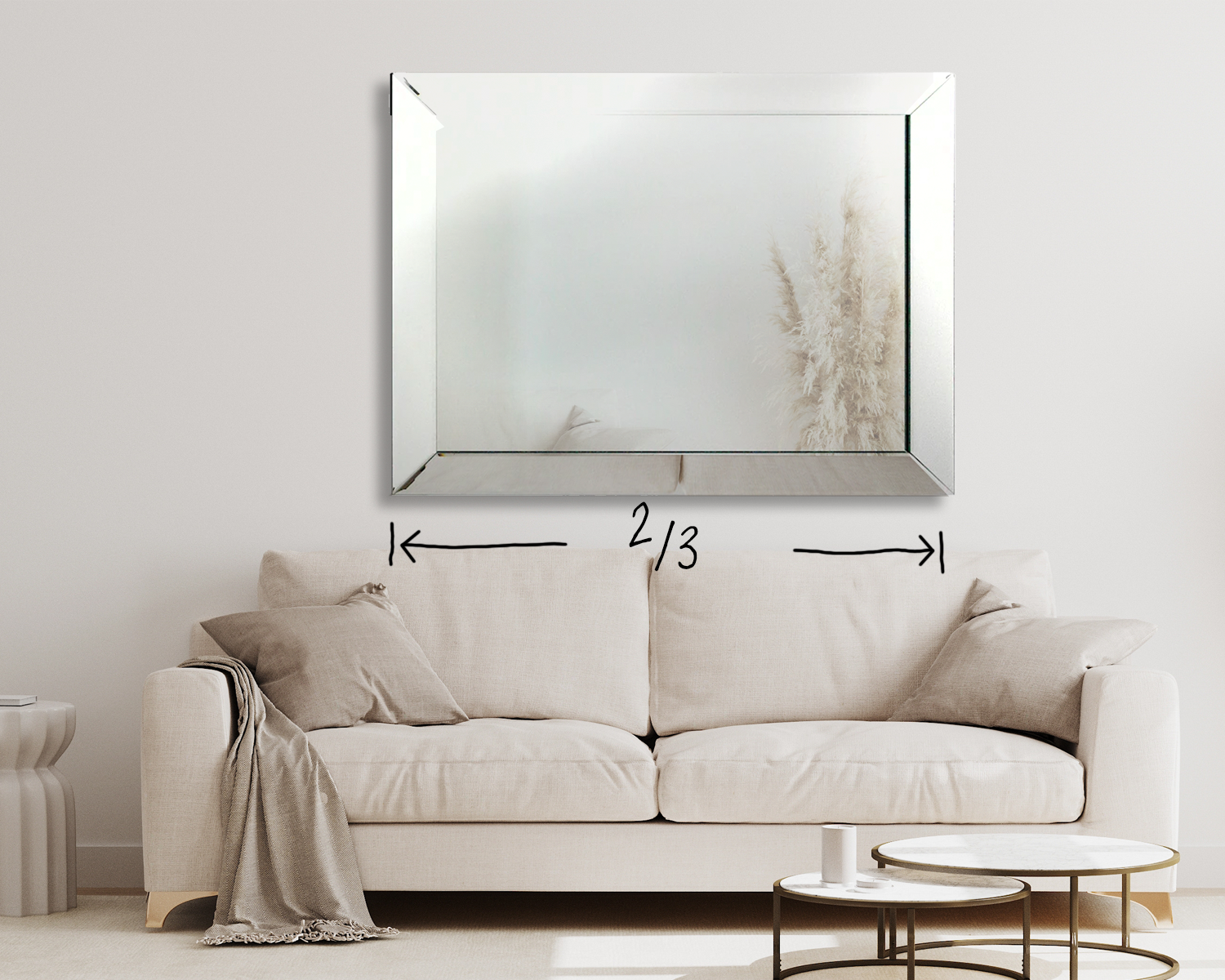 A picture of a mirror hung above a couch that fills 2/3 of the space of the length of the couch