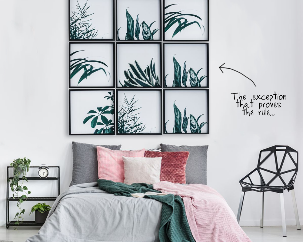 An image of 6 frames with the same size and profile hung above a bed. They are hung closer together than the normal 2 - 3" rule because they have a very thin frame.