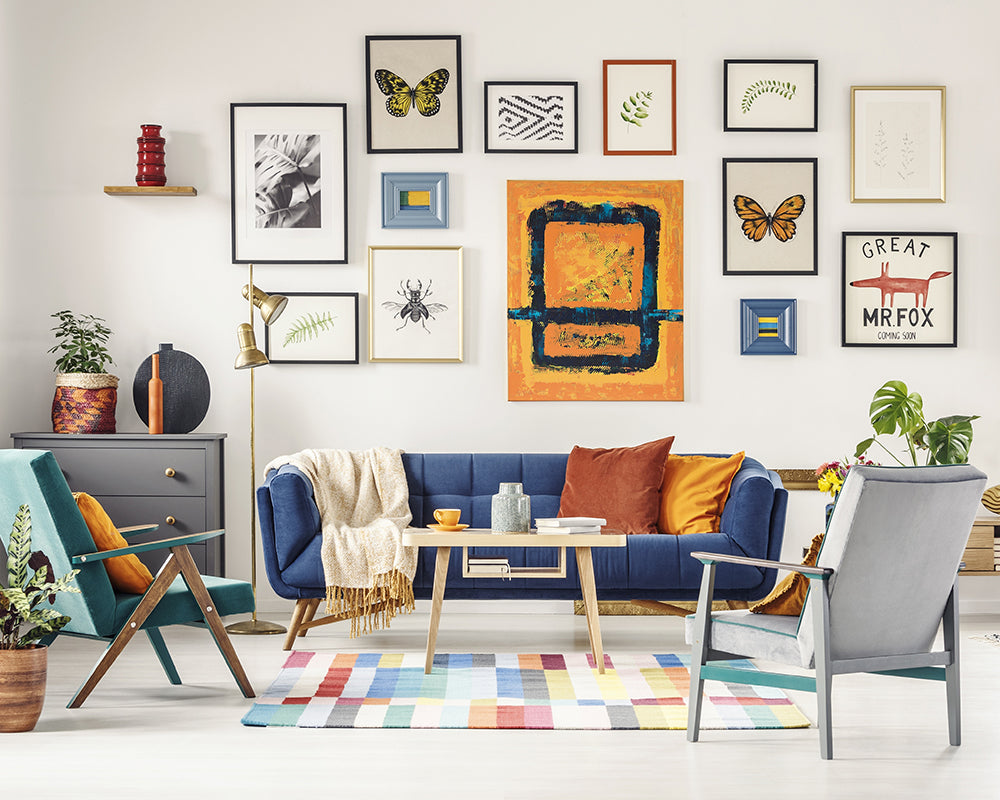 A decorated living room featuring a gallery wall of personal art in a 14 different kinds of frames.