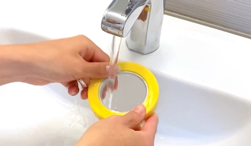 Image of a person washing Doree™ doorstop under the tap to remove the dust and dirt to restore its grip