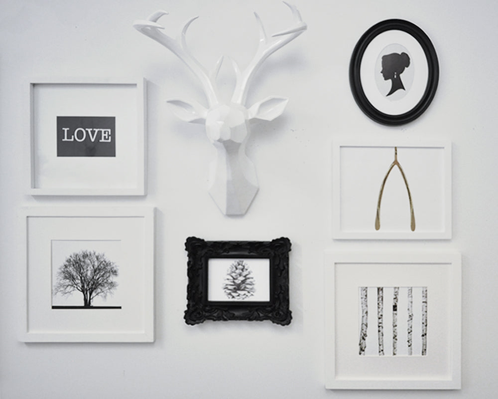 An asymetrical arranged grouping of decor items into a wall gallery where the visual weight of the items is taken into consideration to create visual balance in the arrangement