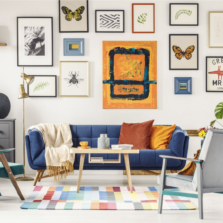 Image of a living room decorated with a large gallery wall over the couch showing it's about presence not perfection.