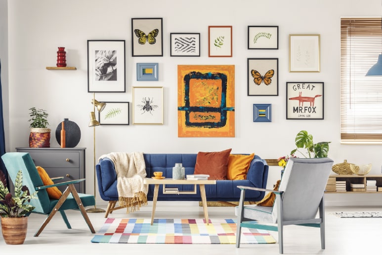 An eclectic 13-frame gallery wall, that emphasizes that you should hang what you love in the way you think it looks best.