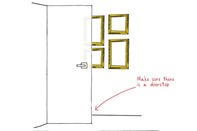 Illustration showing how to hang pictures behind a door in a bathroom.