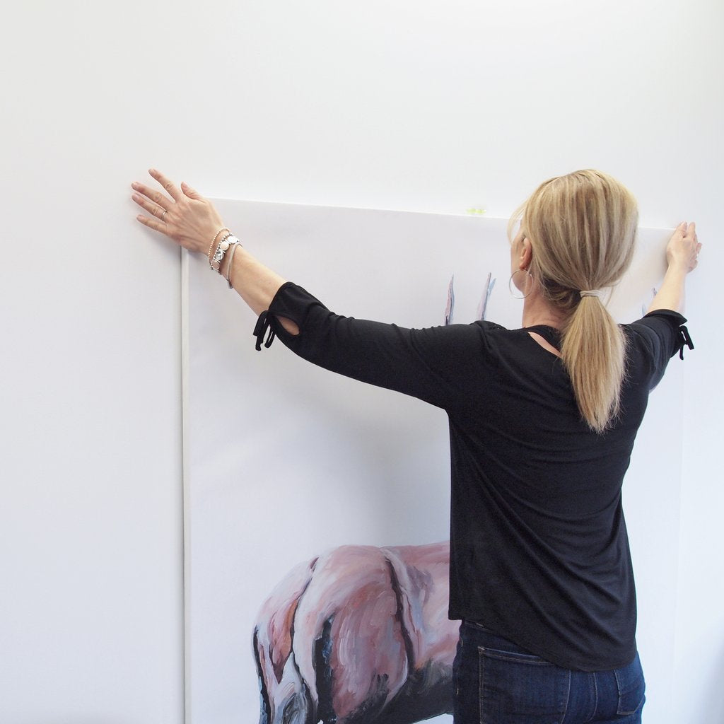 woman hanging large canvas