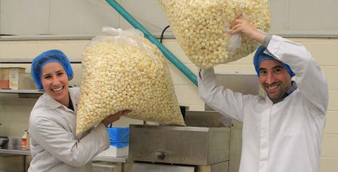 Popcorn Shed founders Sam and Laura in the factory where they watch popcorn being air popped to perfection
