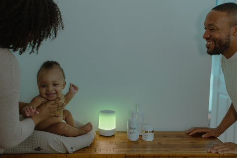 Nanit sound and light pictured with baby and parents and ella ola products