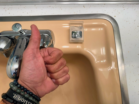 Thumbs up with Infused Black Floss on a sink