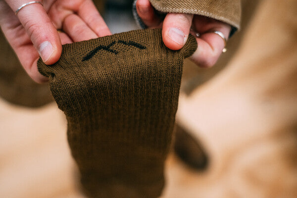 Closeup look at mountain logo stitched into cuff of Darn Tough sock