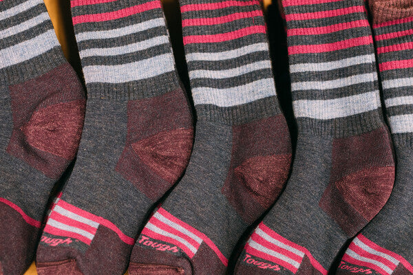 Rows of merino wool socks neatly lined up at Darn Tough