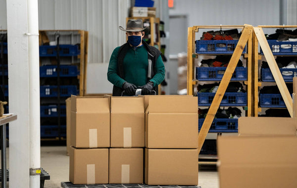 Alex wearing his cowboy hat moving boxes