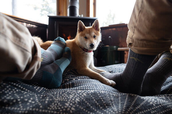 The Salmon Sisters' feet wearing darn tough hiking socks at home by the fire