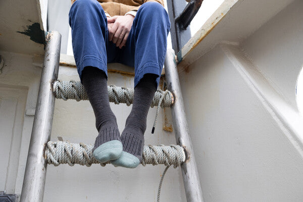 Fisherman seated on boat in Emma Claire socks, close look at the full cushioned toe box