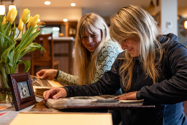 Emma and Claire looking through photo albums at pictures of Stanley K