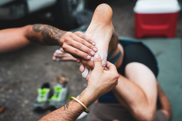 Hands massaging a runner's foot to work out a cramp