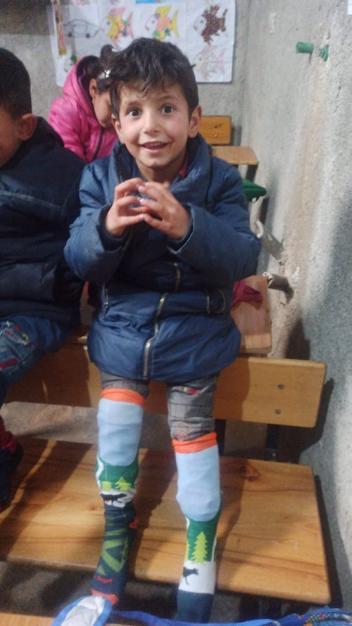 Ali, a little boy, wearing his Darn Tough socks and looking very excited