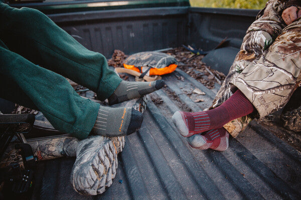 Two pairs of feet wearing darn tough hunting socks