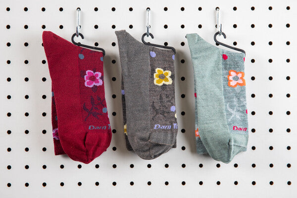 The Eden floral sock in three colors, lined up on the wall