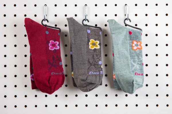 The Eden floral sock in three different colors, red, gray, and blue