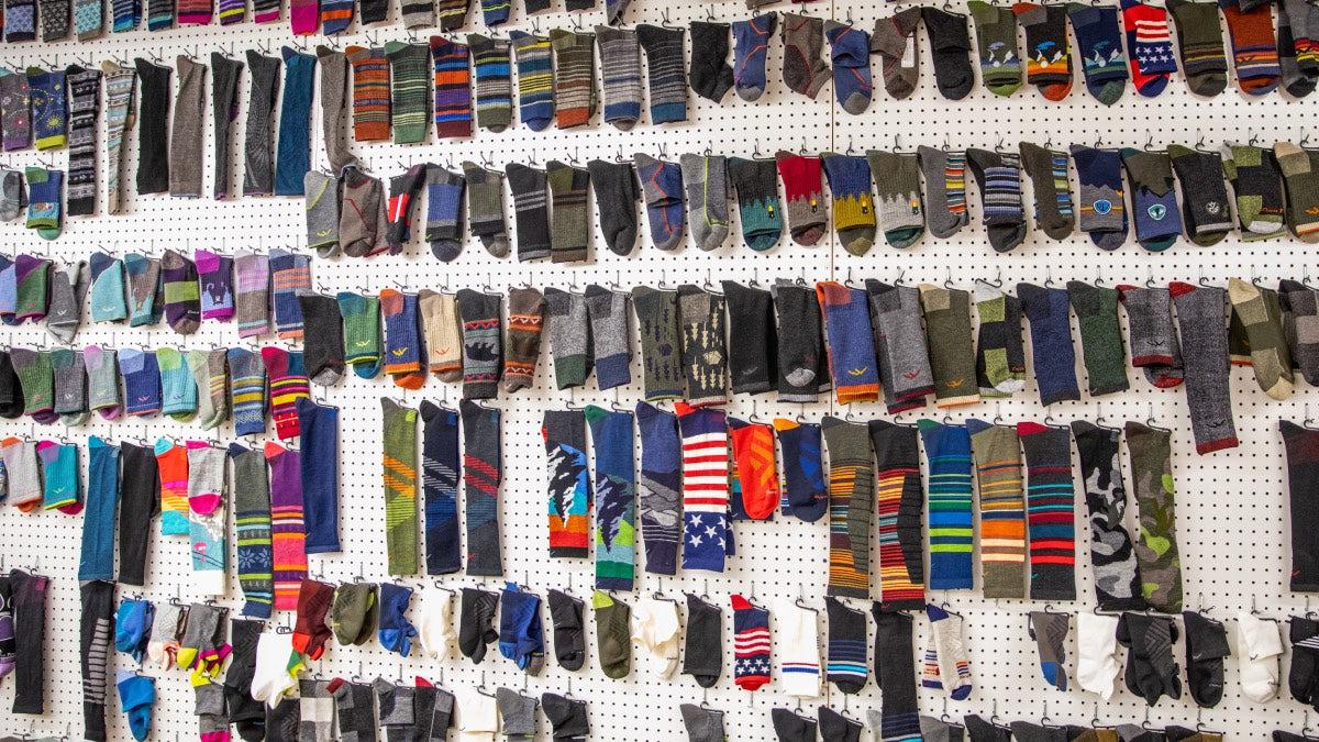 A wall completely covered in Darn Tough socks, dozens of different designs and colors
