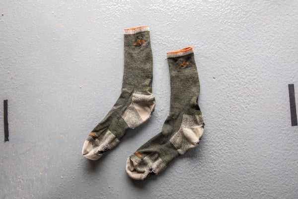 A pair of very old, worn out socks covered under the Darn Tough warranty