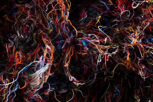 A closeup of a bundle of merino wool yarn scraps in a bunch of colors