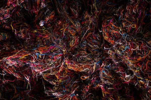 Piles of Merino Wool yarn scraps, in a bunch of colors