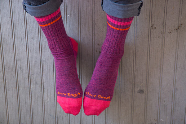 Closeup of feet wearing pink and purple twisted yarn socks, made of soft merino wool