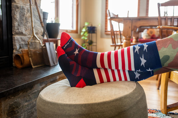Red white and blue socks on feet by a fireplace