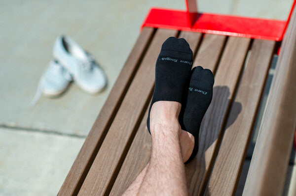 Man seated on bench on hot summer day wearing cooling merino wool socks