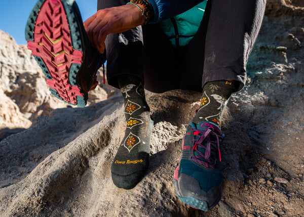 Closeup of feet in Luna hiking socks putting on trail running shoes