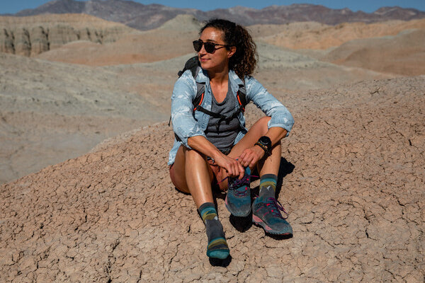 Hiker in the desert putting on shoes over darn tough merino wool socks