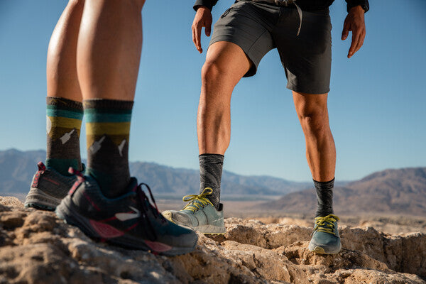Two hikers standing on ridge wearing the Light Hiker Micro Crew and Sunset Ledge socks