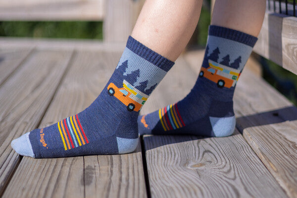 Children's feet wearing the Van Wild hiking socks, with a camper van