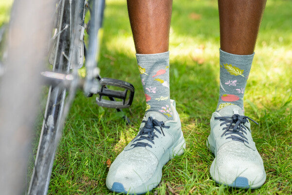 Person with bicycle wearing lightweight socks with a vegetable pattern