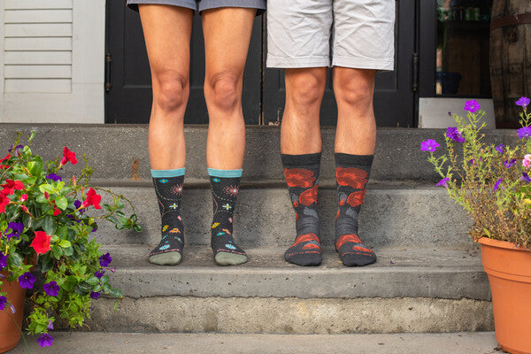 A couple standing on their stoop wearing floral socks from darn tough