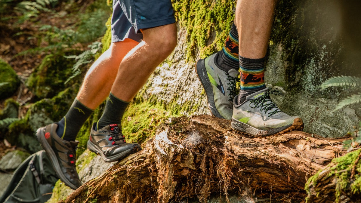 Two hikers heading up the trail with their choice of the best hiking socks from darn tough
