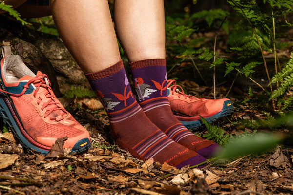 Hiking feet wearing the Critter Club hiking socks with a backpacking hedgehog on them