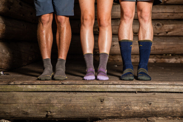 Three hikers wearing three different height hiking socks